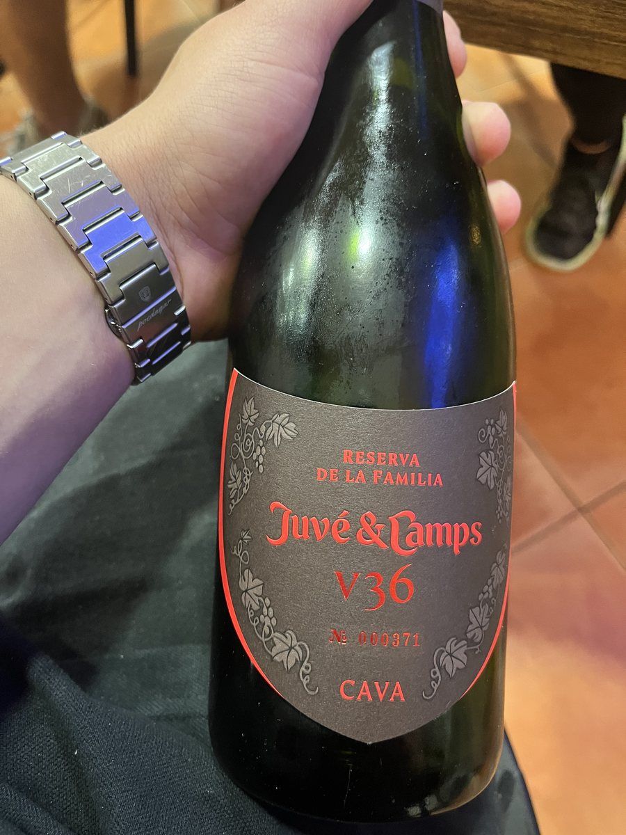 Una botella de cava Juvé y Camps Reserva de la Familia en la mano